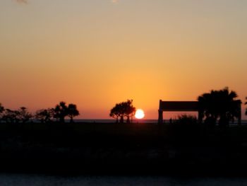 Scenic view of silhouette landscape against orange sky