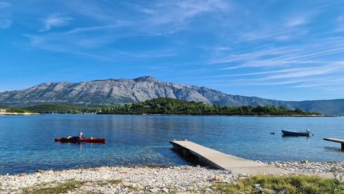 Scenic view of sea and mountains against sky