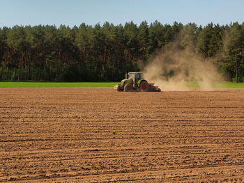 People on agricultural field against sky