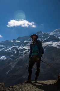 Rear view of man standing on mountain against sky