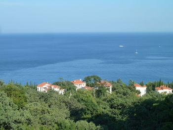 Scenic view of sea by buildings against sky