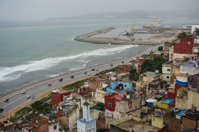 High angle view of buildings by sea against sky