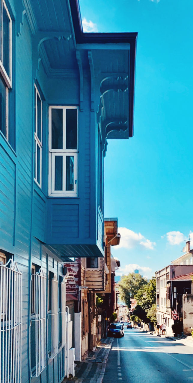 STREET AMIDST BUILDINGS AGAINST SKY