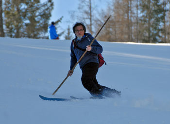 Low angle view of mature man skiing on snow covered mountain