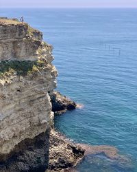 Rock formations by sea against sky