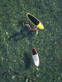 High angle view of shoes on grass by lake