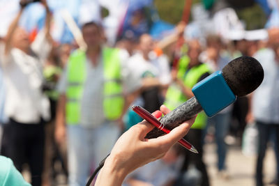 Cropped image of journalist holding microphone