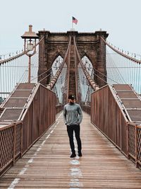 Rear view of man standing on footbridge