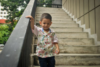 Full length of boy standing on staircase