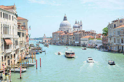 Boats in canal amidst buildings in city