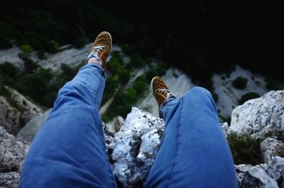 Low section of man sitting on rocks