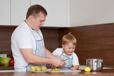 Concept food and nutrition. shot of two cheerful dad and son posing in kitchen