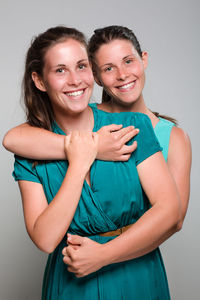 Portrait of a smiling young woman against gray background