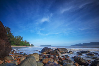 Scenic view of rocky beach against sky