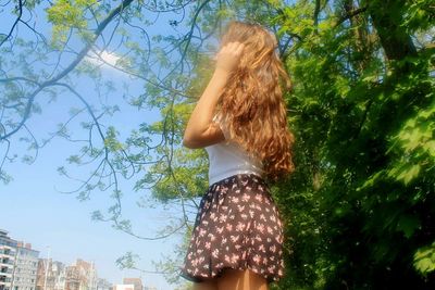 Low angle view of woman in t-shirt and skirt