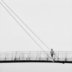 Man standing on bridge against clear sky