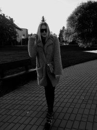 Portrait of woman standing on footpath