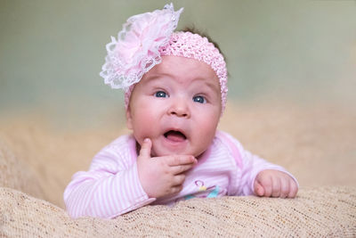 Portrait of cute baby girl lying down on bed