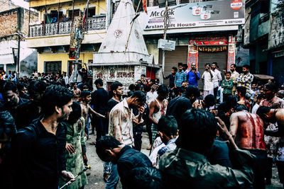 People on street against buildings in city