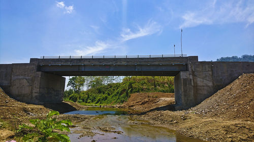 Arch bridge over river against sky