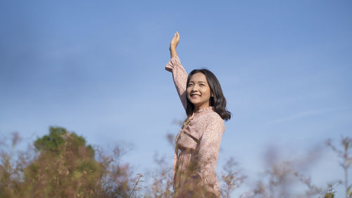 Low angle view of woman standing against sky