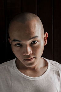 Close-up portrait of young man against black background