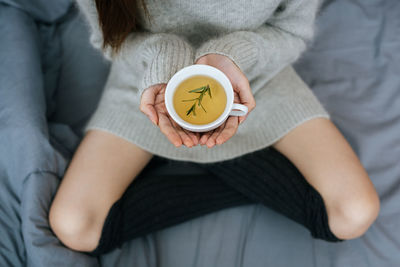 Midsection of woman holding alarm clock