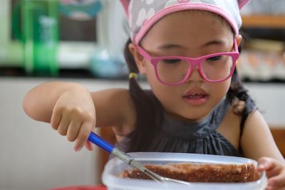 Close-up of cute girl preparing food on table