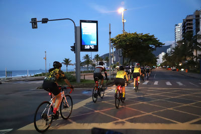 People riding bicycle on road in city