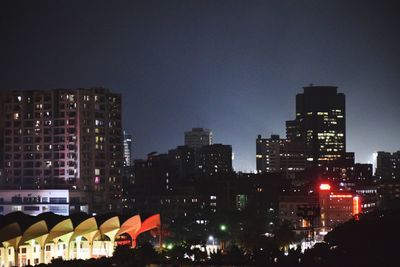 Illuminated buildings against sky at night