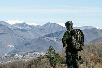 Rear view of man standing against mountain