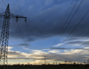 Low angle view of electricity pylon against sky