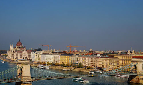 Bridge over river against buildings in city