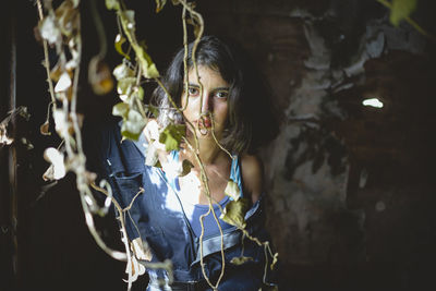 Portrait of woman standing by plant