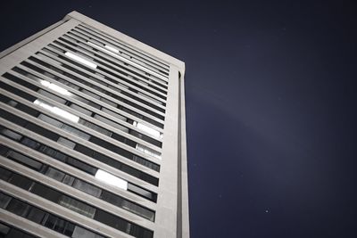 Low angle view of modern building against sky at night