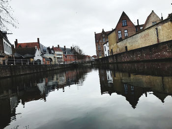 Reflection of buildings in lake against sky