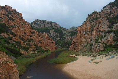 Scenic view of river amidst mountains against sky