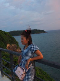 Woman looking at sea against sky