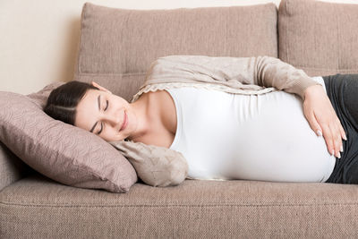 Portrait of woman relaxing on sofa at home