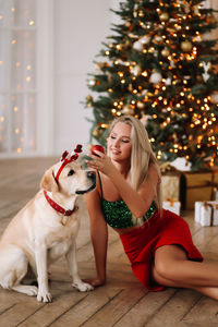 Portrait of young woman with dog at home