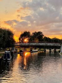 Bridge over river against sky during sunset