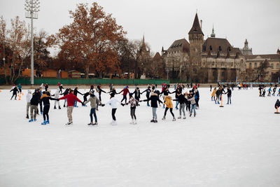 People skating on ice on an ice skating rick with a castle in the background