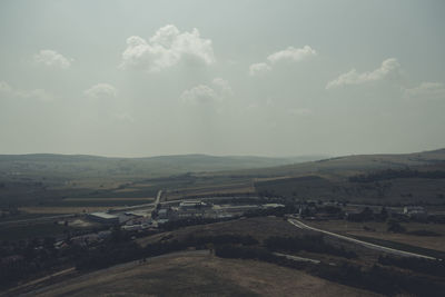 Road by landscape against sky