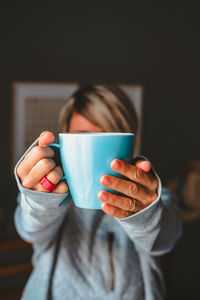 Midsection of woman holding coffee cup