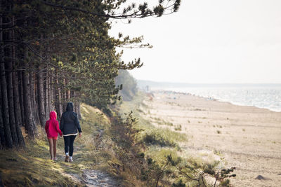 Family walking in forest along beach. summer vacation trip. people spending leisure time.