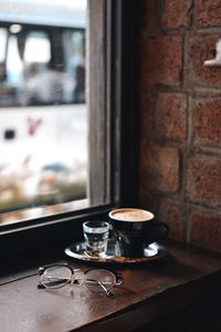Coffee cup and eyeglasses on table
