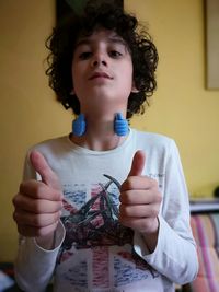 Low angle portrait of boy gesturing thumbs up