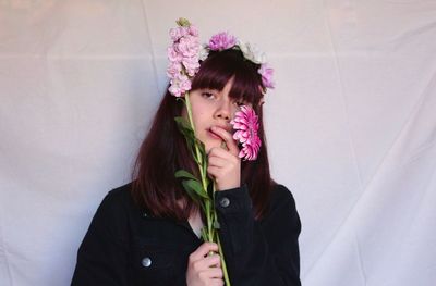 Portrait of a beautiful young woman holding red flower