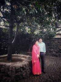 Full length of a girl standing against trees