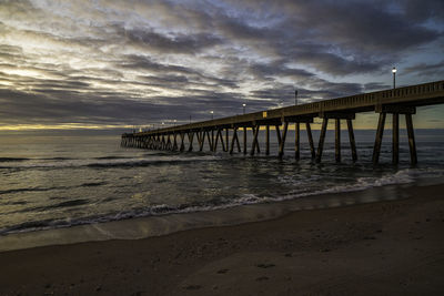 Pier over sea against sky during sunset